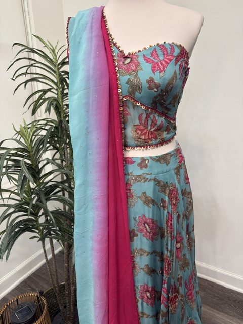 Blue printed lehenga with one-shoulder blouse, angled view showing the embellished bodice and dupatta