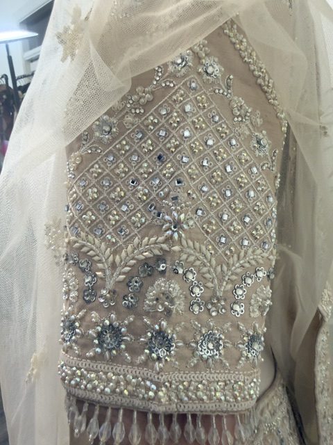 Blush tissue bridal lehenga, mirrored trellis work and beaded fringe on the sleeve