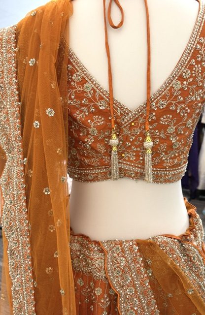 Orange raw silk bridal lehenga, blouse back with tasselled tie cords