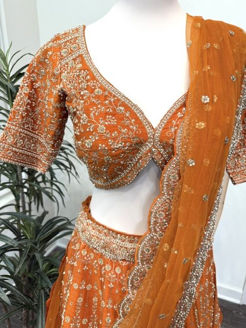 Orange raw silk bridal lehenga, embroidered blouse and scalloped dupatta border detail