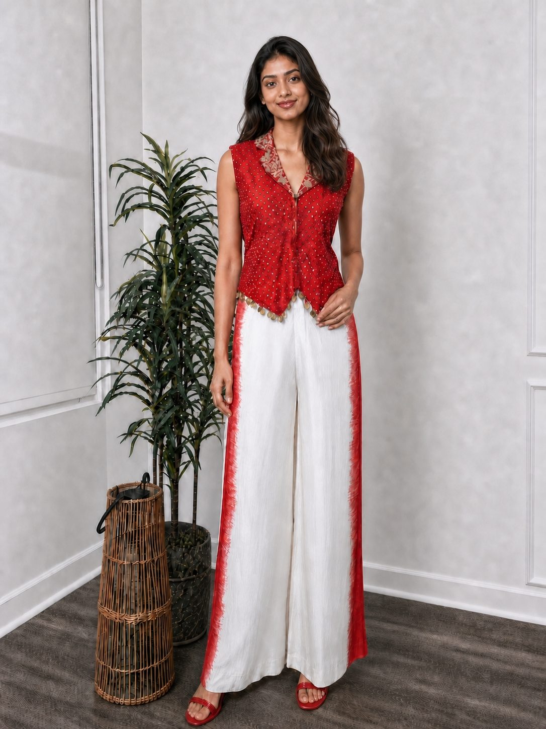 Red bandhani-print top with mirror work and coin-drop hem, worn with ivory and red straight silk pants, full view