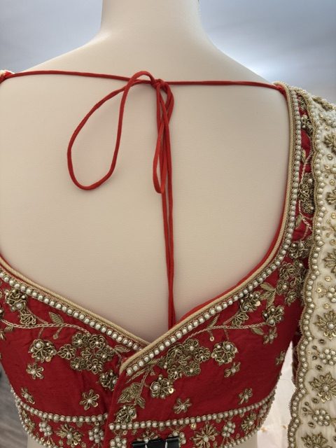 Red raw silk bridal lehenga, blouse back with tie cord and pearl-edged V