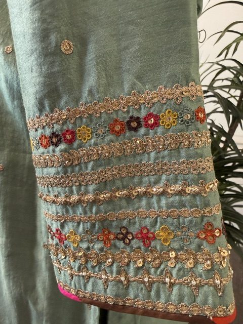 Close view of the sleeve cuff, banded gold embroidery with small multicolour flowers