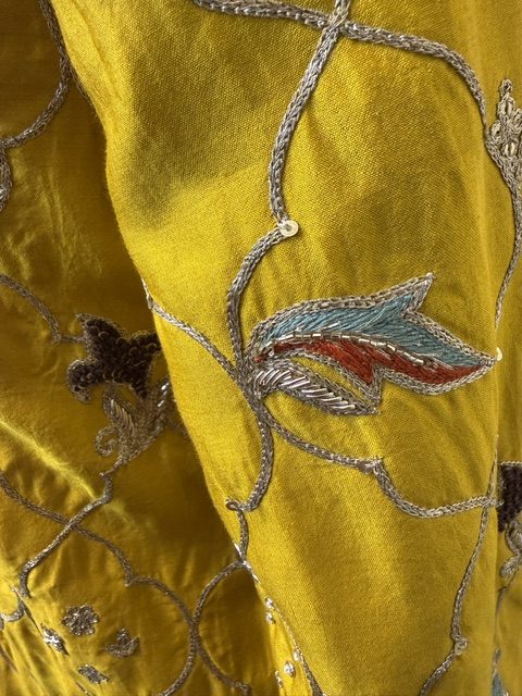 Close view of the ombr&eacute;-dyed organza dupatta, yellow shading into sage with a gold border